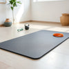 Thick non-slip fitness mat on a home workout floor with minimal exercise gear nearby