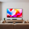 Living room with a large 65-inch flat-screen TV displaying a cinematic scene for budget TV comparison