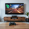 Gaming console and controller beside a large TV displaying a fast action game in a modern living room