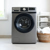 Modern front-loading washing machine with folded towels in a bright, minimal laundry room