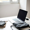 Student laptop on a desk with backpack and notebook in a bright study space