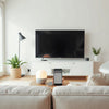 Modern living room with a smart TV showing connected device setup glow and implied voice assistant interaction