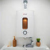 ISI-style geyser with copper-colored heating element and warm outlet steam in a clean bathroom setting