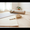 Yoga mat, straps, and bolster arranged neatly with soft natural light for a premium practice setup