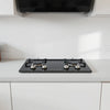 Modern four-burner gas hob on a clean countertop with visible burners and control knobs