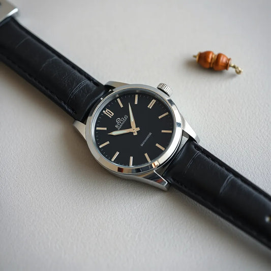 Scratch-resistant glass watch face with subtle reflections resting on a clean leather surface