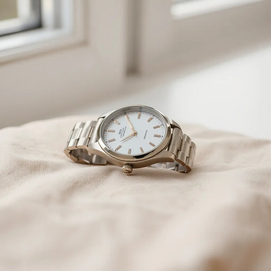 Bracelet-style wristwatch with metal links and clean dial on a neutral fabric background