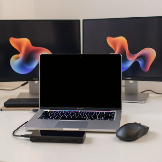 Open high-performance laptop on a clean desk with an external SSD and wireless mouse in soft natural light