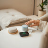 Person interacting with smart home gadgets like a smart speaker, plug, and display in a modern living room