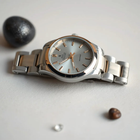 Two-tone stainless steel wristwatch with bracelet and round dial on a neutral background