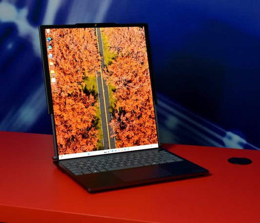 Laptop displaying autumn trees and road